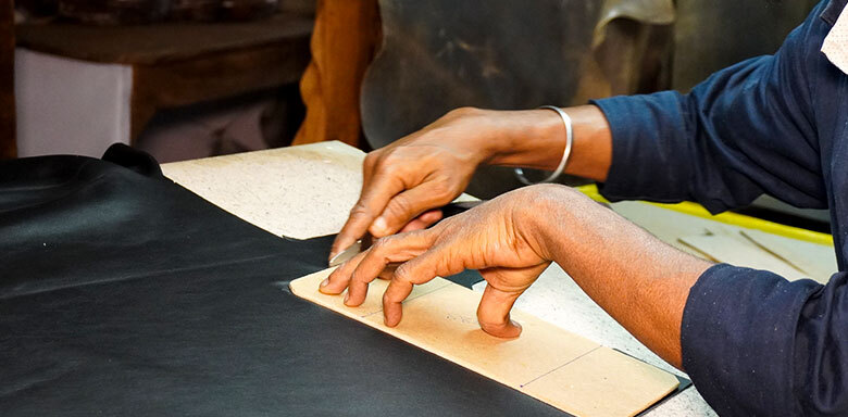 Skilled artisan applying distressing techniques on premium leather for handcrafted bag manufacturing and OEM leather production in India